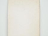 an old book sitting on top of a table next to a white wall