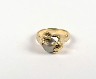 yellow gold ring with a black pearl in the middle of it
