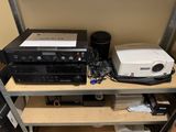 une étagère sur laquelle sont posés une chaîne hi-fi et d'autres appareils électroniques