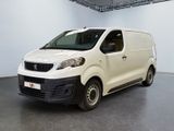 La petite camionnette blanche est garée dans une grande pièce.