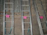 several metal ladders are lined up against a wall in a room