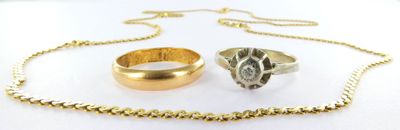two rings and a gold chain on a white surface