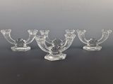 quatre bougeoirs en verre posés sur une surface noire