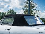 a white car with a black top parked in a parking lot