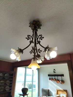 un lustre au milieu d'une pièce où se trouvent une table et des chaises