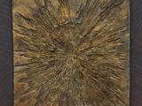 a close up of a piece of wood with a sunburst on it