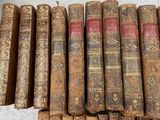 several old books are stacked on top of each other on a table