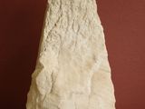 a white rock on a table with a red wall in the background