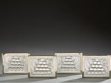 trois vases blancs posés les uns à côté des autres sur une table
