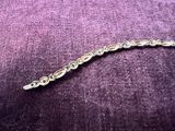 bracelet à chaîne en argent orné de pierres bleues sur un fond de velours violet