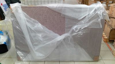 une boîte emballée dans du plastique, posée par terre