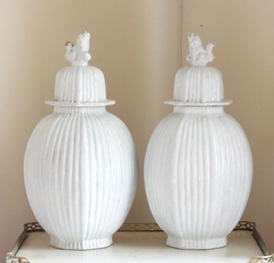 deux vases blancs posés sur une table blanche