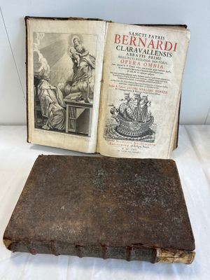 an old book sitting on top of a table next to an open book