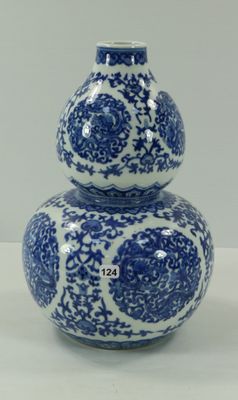 un vase bleu et blanc posé sur une table blanche