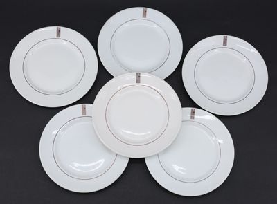 six assiettes plates blanches bordées d'or, disposées en cercle