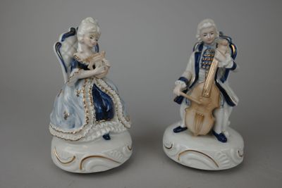 paire de figurines en porcelaine représentant un homme et une femme assis sur une chaise