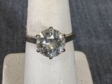 une bague sertie d'un diamant posée sur un présentoir à bagues