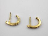 a pair of gold earrings on a white surface