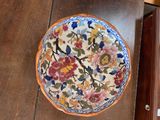 a plate with flowers on it sitting on a wooden table
