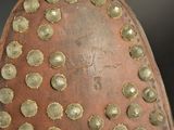 a close up of a brown shoe with gold dots on it