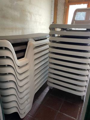 a stack of plastic chairs in a room with a window