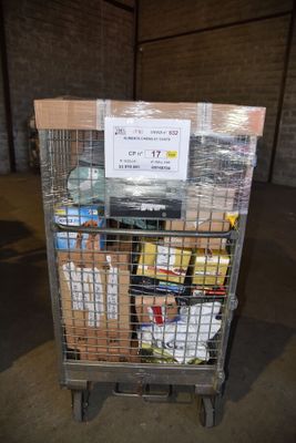 un chariot rempli de provisions dans un entrepôt, sur lequel est accrochée une pancarte