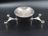 an image of a silver plate with three legs and a bowl on top of it