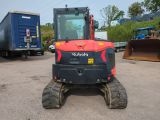 a red and black tractor parked in a parking lot
