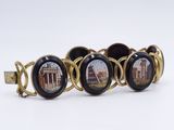 a close up of a bracelet with a picture of a building on it