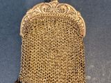 un sac à main en maille dorée à l'ancienne sur fond bleu