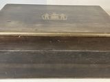 an old wooden box sitting on top of a table next to a vase
