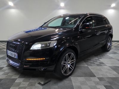 the black audi qx is parked on a checkered tile floor