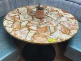 a round table with a marble top on a blue bench