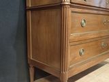 a wooden chest of drawers with marble top