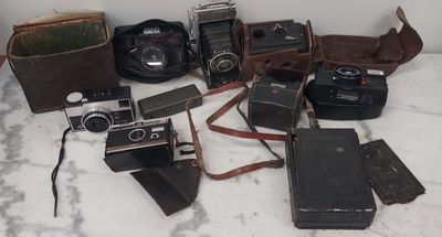un tas de vieux appareils photo posés sur une table