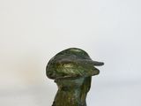 statue d'une femme portant un chapeau et un oiseau perché sur son épaule