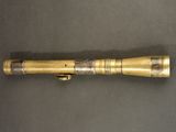an old brass flashlight with a metal handle on a table
