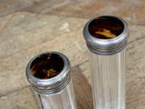 two silver vases sitting on a wooden table