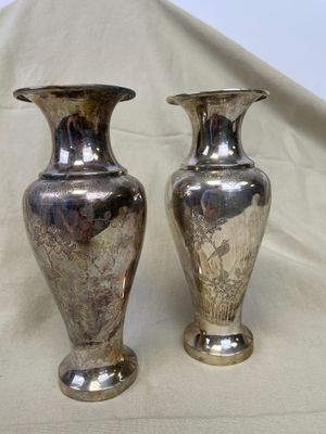 deux vases en argent posés sur un tissu blanc