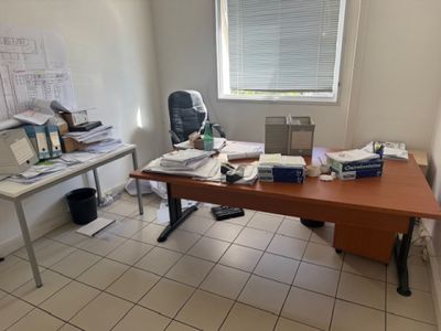 un bureau sur lequel se trouvent un ordinateur, une imprimante et d'autres objets