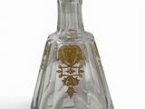 a glass bottle with a gold design on it