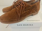 a pair of tan sued shoes on a white box