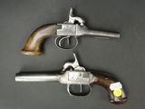 two pistols with wooden grips on a black surface