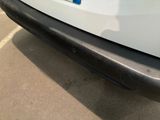 the rear end of a white car with a blue stripe on it