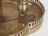a gold candle holder with a candle on top of it