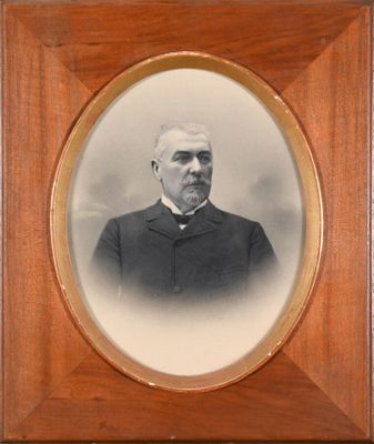 an old photo of a man in a suit and tie in a wooden frame