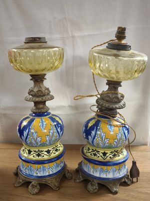 pair of blue and yellow vases on wooden table with white curtain in background