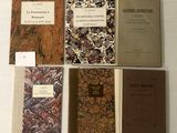 plusieurs livres sont alignés sur une table à fond blanc