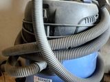 a vacuum that is sitting on the floor next to a wall