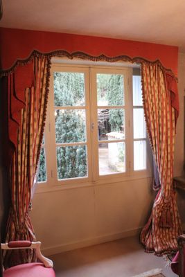 a pink chair in front of a window in a room